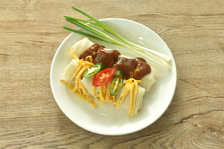 fresh Chinese spring roll made from flour wrapped tofu and pork with bean sprout dressing red gravy sauce on plateの写真素材