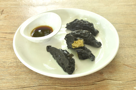 steamed black squid ink Gyoza or Japanese dumpling stuffed mashed pork  curry dipping shoyu sauce on plateの写真素材