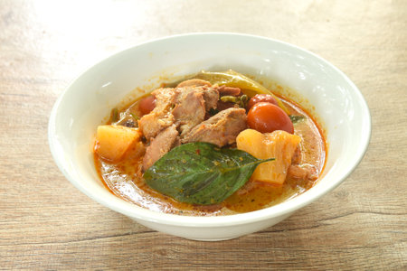 spicy boiled roasted duck meat with pineapple and tomato in coconut milk curry soup on bowlの写真素材