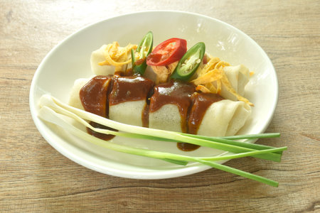 fresh Chinese spring roll made from flour wrapped tofu and pork with bean sprout dressing sweet red gravy sauce on plateの写真素材
