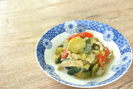 spicy stir fried slice long green eggplant with pork and basil on plateの写真素材
