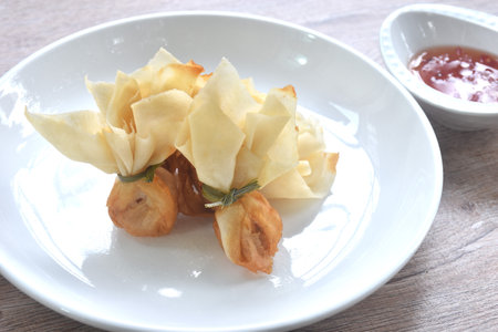 golden bag crispy fried dumpling paste stuffed chop pork and shrimp Thai snack dipping sweet chili plum sauce on cupの写真素材