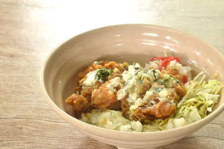 deep fried chicken dressing cream sauce with pickled vegetable and cabbage on rice in bowlの写真素材