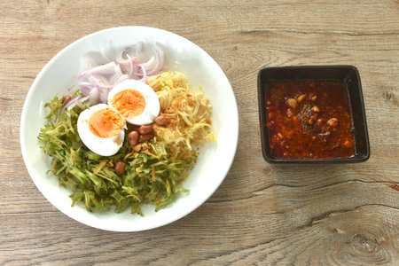spicy and sour slice wing bean and banana blossom with chop pork sauce topping boiled egg Thai salad on plateの写真素材
