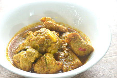 spicy fried pork bone with yellow curry and basil leaf Thai southern food on bowlの写真素材