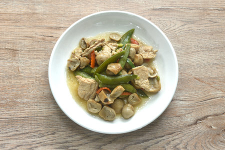 stir fried green pea and straw mushroom with pork in soybean sauce on plateの写真素材