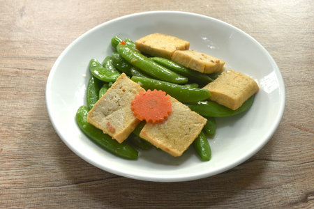 stir fried garden pea and carrot with slice tofu in soy sauce vegetarian foodの写真素材
