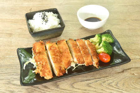 fried chicken with bred flour or Karaage topping vegetable with rice dressing black sesame dipping sweet black soy sauceの写真素材