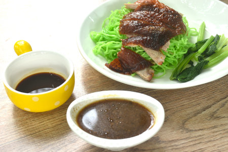 Chinese jade noodles topping roasted duck meat dipping sweet soy sauce on plateの写真素材