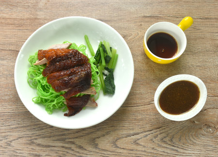 Chinese jade noodles topping roasted duck meat dipping sweet soy sauce on plateの写真素材