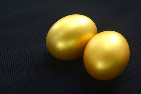 golden egg shell arranging on black backgroundの写真素材