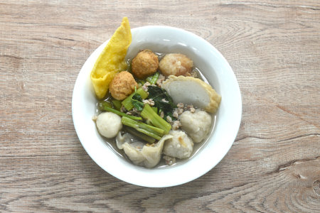 boiled fish ball with dumpling topping shrimp ball and morning glory in clear soup on bowlの写真素材