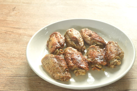 grilled salty and spicy chicken wing with black pepper on plateの写真素材