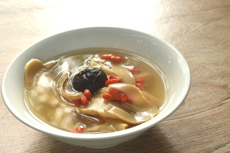 boiled slice Chinese bamboo shoot with goji berry and mushroom clear soup on bowlの写真素材