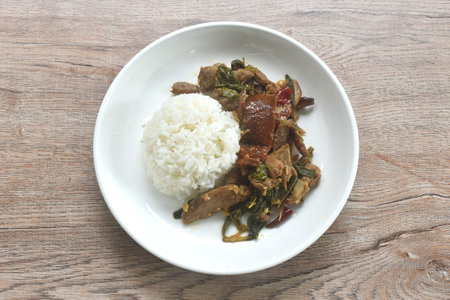 spicy stir fried slice sweet roasted duck meat with chili and basil on rice in plateの写真素材