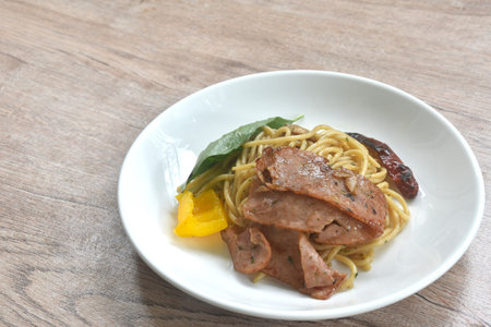 fried spaghetti topping crispy pork bacon and slice dry chili with bell pepper on plateの写真素材