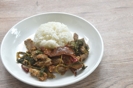 spicy stir fried slice sweet roasted duck meat with chili and basil on rice in plateの写真素材
