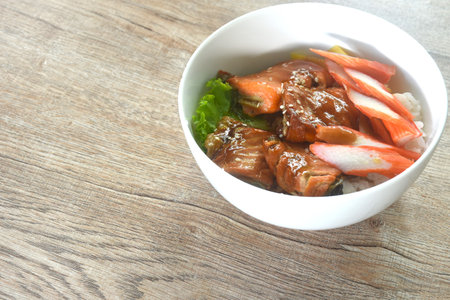grilled saba fish or mackerel topping crab stick and lettuce on japanese rice in bowlの写真素材
