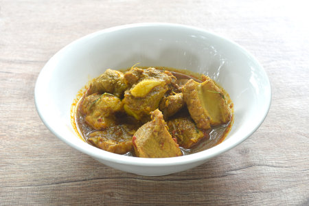 spicy fried pork bone with yellow curry and basil leaf Thai southern food on bowlの写真素材
