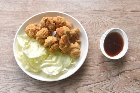 deep fried crispy fish ball dressing sweet chili tamarind sauce and slice cabbage on plateの写真素材