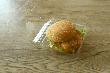 fried mashed shrimp hamburger and lettuce stuffed mayonnaise sauce with ketchup in plastic pakaging on tableの写真素材