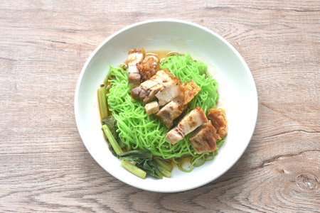 Chinese jade noodles topping roasted crispy pork dipping sweet soy sauce on plate
