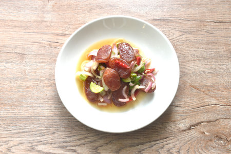 spicy and sour sweet slice Chinese pork sausage with vegetable salad on plateの写真素材
