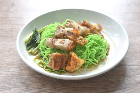 Chinese jade noodles topping roasted crispy pork dipping sweet soy sauce on plate