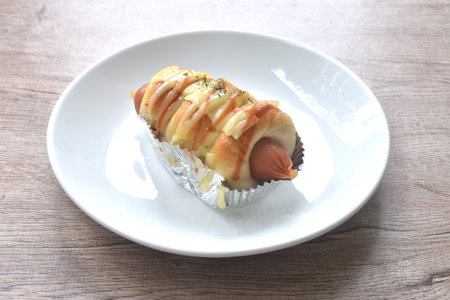 baking bread stuffed smoky pork cheese sausage dressing mayonnaise sauce and oregano on aluminum foil in plateの写真素材