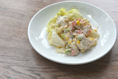 mashed tuna with corn and garden pea couple cabbage vegetable salad dressing cream sauce on plateの写真素材