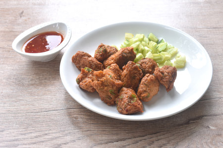 deep fried grouper fish patty on plate with slice cucumber dipping sweet chili sauceの写真素材