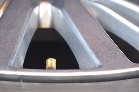 brass screw tire value on magnesium alloy wheel background and textureの写真素材
