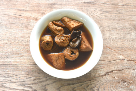 boiled slice tofu and gluten with black mushroom herb soup vegetarian food on plateの写真素材