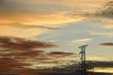 high voltage electric pole on twilight sunset sky in eveningの写真素材