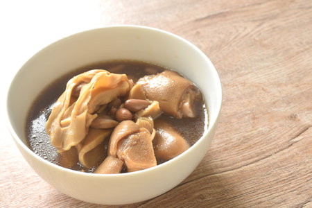 boiled slice Chinese bamboo shoot with pork leg and peanut in clear soup on bowlの写真素材