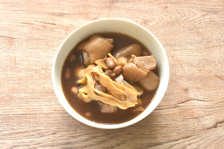 boiled slice Chinese bamboo shoot with pork leg and peanut in clear soup on bowlの写真素材