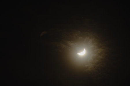 half moon covering by cloud floating on sky in night backgroundの写真素材