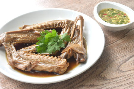chop boiled duck wing and beak with tongue stew in brown soy soup on plate dipping spicy sour chili sauceの写真素材