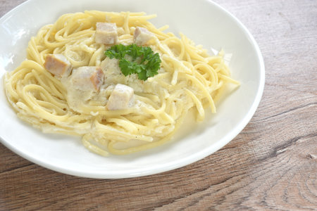 steamed spaghetti white cabonara cream sauce topping slice mushroom on plateの写真素材