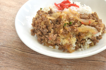 fried ground beef with onion or soboro donburi on rice black sesame topping pickled red ginger on plateの写真素材