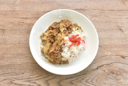 fried ground beef with onion or soboro donburi on rice black sesame topping pickled red ginger on plateの写真素材