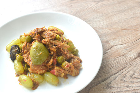 spicy fried roasted duck meat with grape and eggplant in curry on plateの写真素材