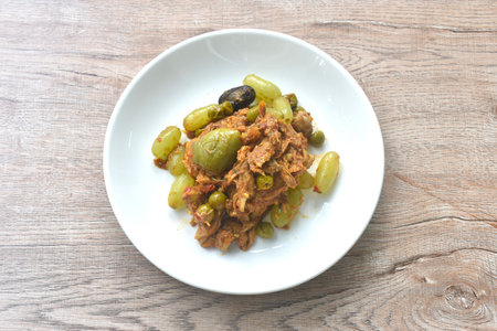 spicy fried roasted duck meat with grape and eggplant in curry on plateの写真素材