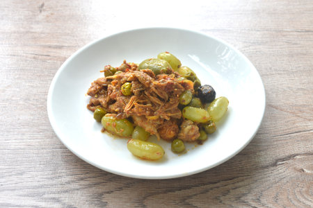 spicy fried roasted duck meat with grape and eggplant in curry on plateの写真素材