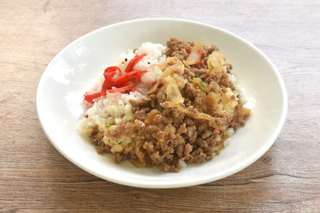 fried ground beef with onion or soboro donburi on rice black sesame topping pickled red ginger on plateの写真素材