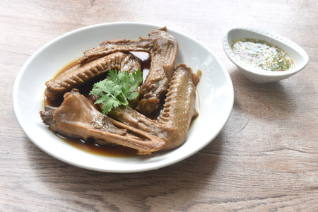 chop boiled duck wing and beak with tongue stew in brown soy soup dipping spicy sour chili sauceの写真素材