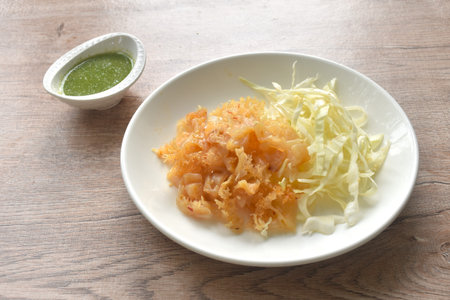 boiled jellyfish with slice cabbage on plate dipping Thai spicy and sour seafood sauceの写真素材