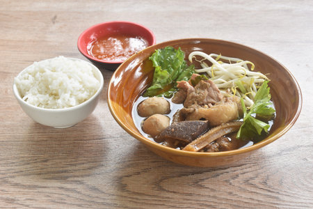 boiled braised beef meat and tendon couple organ in herb brown soup on bowl dipping spicy chili...
