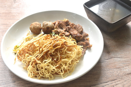 dry boiled Chinese yellow egg noodles with braised beef and meatball dressing black sweet soy sauce...