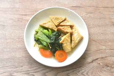 stir fried Chinese cabbage with needles mushroom and carrot topping tofu in soy sauce on plateの写真素材